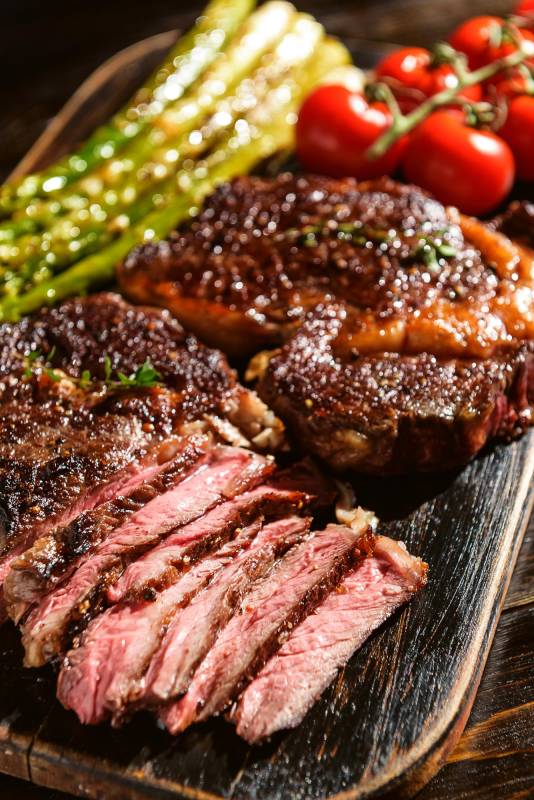 $!Dinner for two juicy delicious steaks, asparagus with parmesan and vegetables.