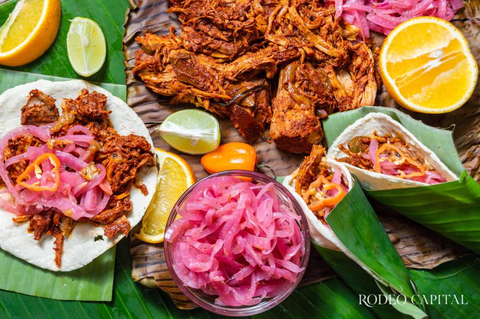 $!Cochinita Pibil, Mexican pit-roasted pork dish from Yucatan, on banana leaves with traditional condiments. Tacos and tostadas from Mexico.